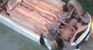 Condutor cai com veículo em córrego e escapa pela janela