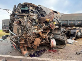 Carretas batem de frente, motorista morre e carga de soja se espalha