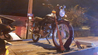 Jovem empina moto em frente à polícia, foge, cai e para na delegacia