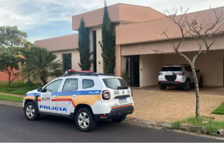 Equipe da Polícia Militar de MG em frente a casa de um dos alvos da operação (Foto: Divulgação)
