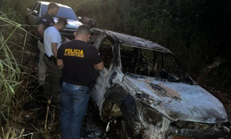 Policiais paraguaios ao lado da caminhonete de engenheiro, queimada em área de mata (Foto: Divulgação)