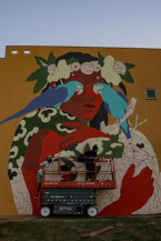 Wes Gama produzindo seu mural com uma de suas marcas atualmente, os pássaros sobre os olhos dos personagens. Fotos: Raique Moura
