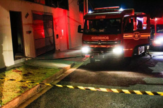 Caminhão dos bombeiros e fita zebrada isolam local do crime. (Foto: Juliano Almeida/Campo Grande News)