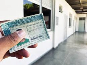 Cidadã segura a própria CNH, documento que autoriza a condução de veículos em território nacional.