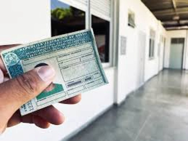 Cidadã segura a própria CNH, documento que autoriza a condução de veículos em território nacional.