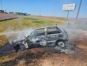 Fiat Uno totalmente incendiado após perseguição na BR-163 (Foto: Tá na Mídia Naviraí)