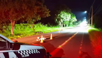 Corpo de Vinícius no meio da rua e motocicleta às margens da pista (Foto: Jardim MS News)