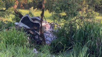 SUV Veracruz ficou destruída e pacotes de cigarro espalhados após bater em árvore (Foto: Corpo de Bombeiros)