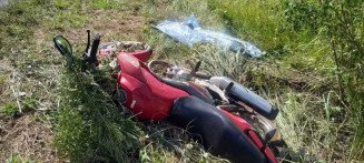 Corpo da vítima ao lado da motocicleta usada no acidente. (Foto: Fronteira News)
