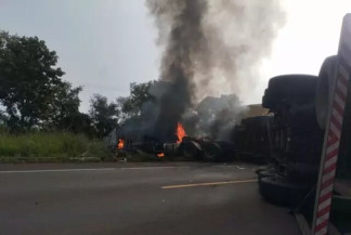 Cabine de uma das carretas pegando fogo após tombar na pista (Foto: Diário Popular)