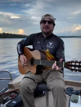 Compositor Paulo Fiapo tocando violão que foi extraviado na BR-163 durante viagem (Foto: Redes sociais / paulofiapooficial)